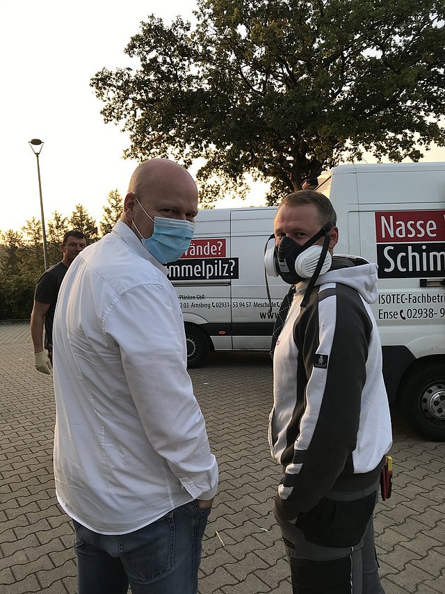 Chef und Mitarbeiter am Morgen mit Maske unterwegs